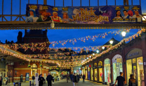 Shoppers exploring the Windsor Christmas Market decorated with festive lights